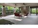 Covered patio featuring stone columns, an outdoor fireplace, and comfortable seating at 6454 Meridian Way, Atlanta, GA 30328