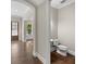 Hallway view showing a powder room with hardwood floors, a pedestal sink, and a modern toilet at 6454 Meridian Way, Atlanta, GA 30328