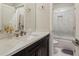Modern bathroom with sleek dark wood vanity, a bright white sink and a marble-tiled shower and tub at 823 Canterbury Overlook, Atlanta, GA 30324