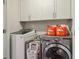 Functional laundry room with front-load washer and dryer, complete with white cabinets for convenient storage solutions at 823 Canterbury Overlook, Atlanta, GA 30324