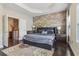 Main bedroom featuring a decorative stone wall, hardwood floors, and tray ceilings at 823 Canterbury Overlook, Atlanta, GA 30324