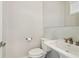 Neutral powder room featuring a pedestal sink, toilet, large mirror, and decorative backsplash at 823 Canterbury Overlook, Atlanta, GA 30324