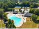 Aerial view of community pool, clubhouse, playground and tennis courts surrounded by trees at 4580 Cloister Cir, Hampton, GA 30228