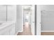 Neutral bathroom featuring tile floors, a white vanity, and a hallway to a naturally lit room at 4580 Cloister Cir, Hampton, GA 30228