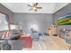 Bonus room with gray walls, a large TV, a ceiling fan, black sectional, and beige carpet at 4580 Cloister Cir, Hampton, GA 30228