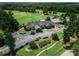 Overhead view of the golf course clubhouse and parking lot surrounded by mature trees and greenery at 4580 Cloister Cir, Hampton, GA 30228