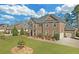 Charming brick home with attached garage, lush landscaping, and gray roof at 4580 Cloister Cir, Hampton, GA 30228