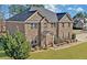 Charming brick home with attached garage, lush landscaping, and gray roof at 4580 Cloister Cir, Hampton, GA 30228