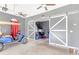 Garage featuring a gray wall, multiple ceiling fans, golf cart and sliding barn doors at 4580 Cloister Cir, Hampton, GA 30228