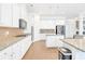 Bright kitchen with white cabinetry, stainless appliances, granite counters, and hardwood floors at 4580 Cloister Cir, Hampton, GA 30228