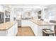 Bright kitchen with white cabinetry, granite counters, stainless appliances and island at 4580 Cloister Cir, Hampton, GA 30228
