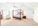 Spacious main bedroom with a four-poster bed, vaulted ceilings, and an abundance of natural light at 4580 Cloister Cir, Hampton, GA 30228