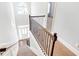 Carpeted staircase with dark wooden handrail leading to a bright entryway and a chandelier at 4580 Cloister Cir, Hampton, GA 30228