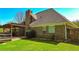Exterior view of a brick home with a pergola-covered deck, surrounded by a well-maintained lawn and privacy fence at 925 Wynn Rd, Mcdonough, GA 30252
