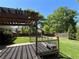 Well-maintained backyard featuring a wooden deck, pergola, lush green lawn, and privacy fence at 925 Wynn Rd, Mcdonough, GA 30252