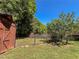 View of a backyard featuring lush greenery, a chain-link fence, and a wooden storage shed at 925 Wynn Rd, Mcdonough, GA 30252