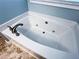 Close up of a soaking tub with brushed gold fixtures at 925 Wynn Rd, Mcdonough, GA 30252
