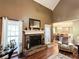 Close up of the living room fireplace with windows on either side, hardwood floors, and a view to the dining room at 925 Wynn Rd, Mcdonough, GA 30252