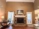 Close up of the living room fireplace with windows on either side, hardwood floors, and mantle decor at 925 Wynn Rd, Mcdonough, GA 30252