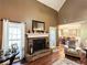 Close up of the living room fireplace with windows on either side, hardwood floors, and a view to the dining room at 925 Wynn Rd, Mcdonough, GA 30252