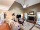 Comfortable living room boasts a vaulted ceiling, fireplace, mounted television, and hardwood floors at 925 Wynn Rd, Mcdonough, GA 30252