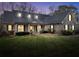 Evening view of a brick home with illuminated windows, a covered porch, and landscaped yard at 4111 Alayna Lee Cir, Mcdonough, GA 30252