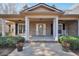 Charming front porch with white columns, brick facade, and colorful flower pots at 4111 Alayna Lee Cir, Mcdonough, GA 30252