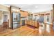 Open-concept kitchen boasts stainless steel appliances, wood cabinetry and a hardwood floor at 4111 Alayna Lee Cir, Mcdonough, GA 30252