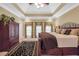 Spacious main bedroom featuring a tray ceiling, dark wood furniture, and light-filled windows with stylish valances at 4111 Alayna Lee Cir, Mcdonough, GA 30252