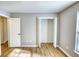 An airy bedroom with hardwood floors, neutral walls, and open closet and doorway at 61 Andrew Rd, Covington, GA 30016
