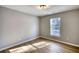 This bedroom features hardwood floors, a window letting in natural light, and neutral walls at 61 Andrew Rd, Covington, GA 30016
