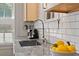 Close-up of a kitchen sink with white subway tile backsplash, marble countertops, and modern fixtures at 794 Frederica Ne St # 2, Atlanta, GA 30306