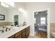 Well-lit bathroom with double sinks, quartz counters, bathtub, and shower at 1323 Faircrest Way, Suwanee, GA 30024