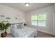Comfortable bedroom with a window, gray carpet, light-colored walls, and a ceiling light fixture at 1323 Faircrest Way, Suwanee, GA 30024