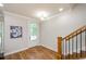 Bright entryway with wood floors, white door, and stairs with wooden railing at 1323 Faircrest Way, Suwanee, GA 30024