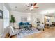 Bright and airy living room with wood floors, ceiling fan, and a view into dining area at 1323 Faircrest Way, Suwanee, GA 30024