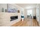 Living room featuring a modern fireplace, hardwood floors, and a view to office space at 1323 Faircrest Way, Suwanee, GA 30024