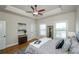 Bright main bedroom featuring a tray ceiling, ceiling fan, and hardwood floors at 1323 Faircrest Way, Suwanee, GA 30024
