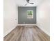 This bedroom features light wood floors, a ceiling fan, and a window overlooking the trees outside at 3185 Hammarskjold Dr, East Point, GA 30344