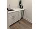 Modern wet bar features white cabinets, quartz counters, sleek hardware, and a beverage fridge at 3185 Hammarskjold Dr, East Point, GA 30344