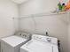 A bright laundry room with a washer, dryer, and storage shelf for convenience at 3795 Soapstone Rd, Decatur, GA 30034