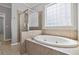 A stylish bathroom featuring a glass-enclosed shower and a luxurious oval soaking tub at 4114 Bigsage Dr, College Park, GA 30349
