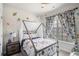 A bedroom has decorative curtains and a cozy bed and adjacent nightstand with lamp at 515 Vandenburg Dr, Villa Rica, GA 30180