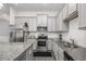 Modern kitchen featuring gray cabinets, stainless steel appliances, and a granite countertop at 515 Vandenburg Dr, Villa Rica, GA 30180
