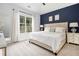 Bright main bedroom with a vaulted ceiling, dark accent wall, and a large window overlooking wooded backyard at 515 Vandenburg Dr, Villa Rica, GA 30180