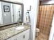 Bathroom with a vanity with a granite countertop, a framed mirror, and a shower with a beige shower curtain at 703 Gettysburg Pl, Atlanta, GA 30350
