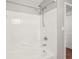 Bright bathroom featuring a tub with a shower, white tile surround, and chrome fixtures at 1101 Juniper Ne St # 415, Atlanta, GA 30309