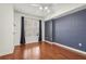 Bedroom featuring wood floors, a dark accent wall, window with curtains and ceiling fan at 1101 Juniper Ne St # 415, Atlanta, GA 30309