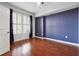 Stylish bedroom featuring hardwood floors, an accent wall, and a window with custom plantation shutters at 1101 Juniper Ne St # 415, Atlanta, GA 30309