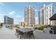 A rooftop deck with chairs, tables, greenery, and city views at 1101 Juniper Ne St # 415, Atlanta, GA 30309